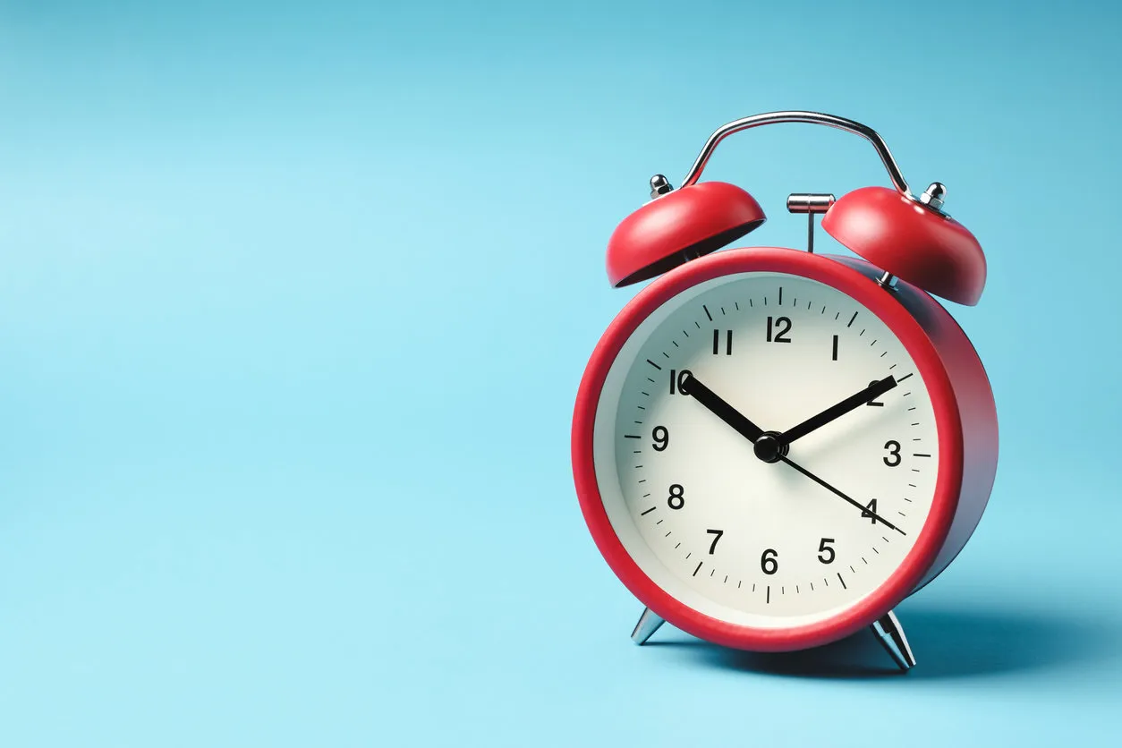 red vintage alarm clock on light blue color background red vintage alarm clock on light blue color background
