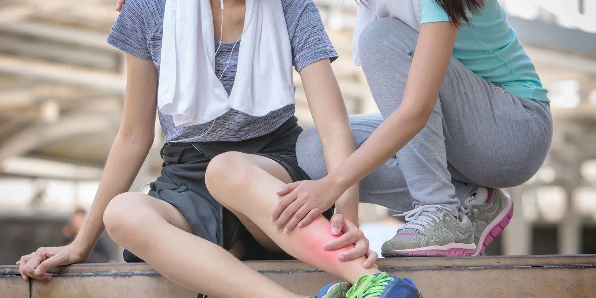 blessure de sport, jeune femme de remise en forme tenant sa jambe avec douleur blessure de sport, jeune femme de remise en forme tenant sa jambe avec douleur