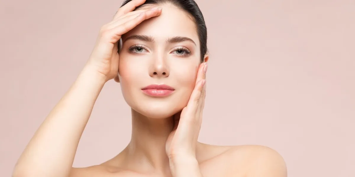 woman natural beauty makeup portrait, fashion model touching face by hands, beautiful girl skin care and treatment, shot over beige studio background woman natural beauty makeup portrait, fashion model touching face by hands, beautiful girl skin care and treatment, shot over beige studio background