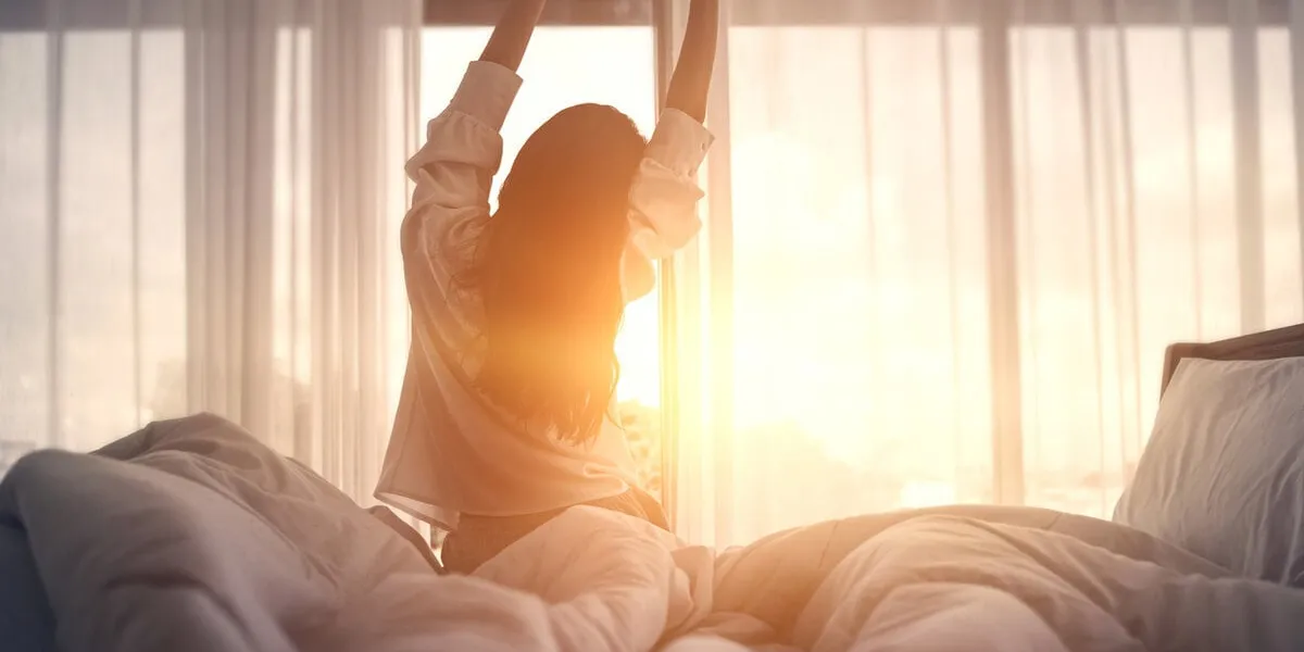 happy woman stretching in bed after waking up happy young girl greets good day happy woman stretching in bed after waking up happy young girl greets good day