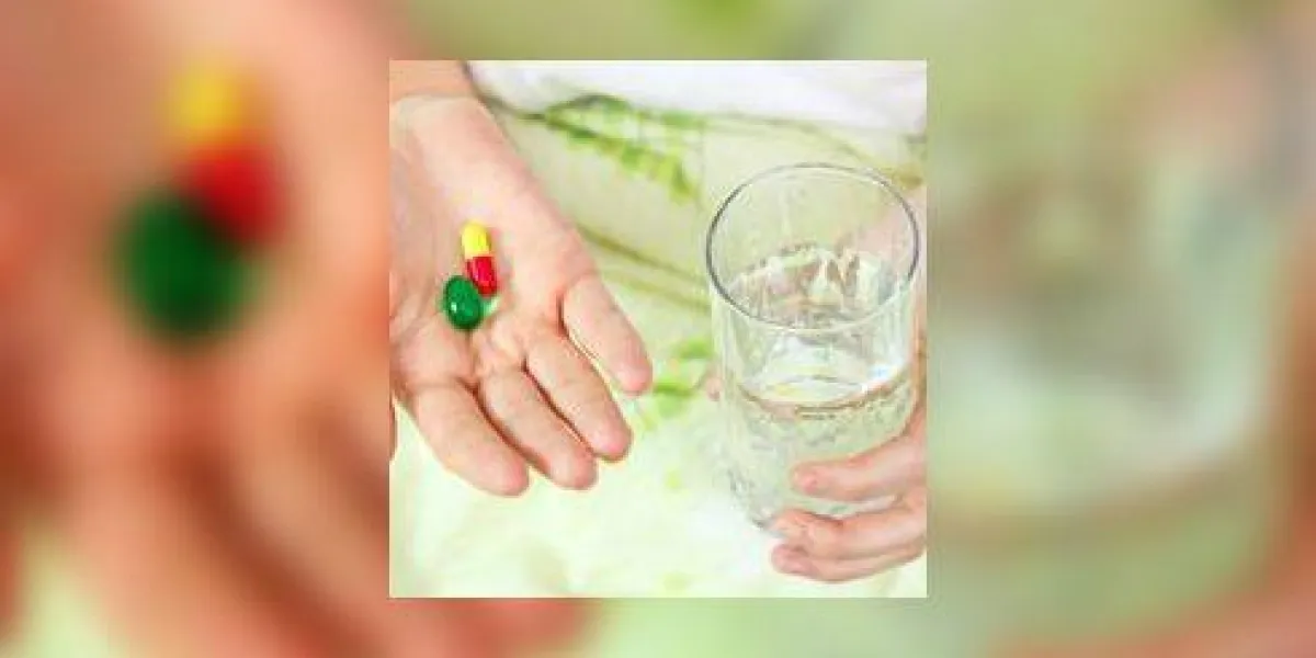 femme tenant deux pilules et un verre d'eau femme tenant deux pilules et un verre d'eau