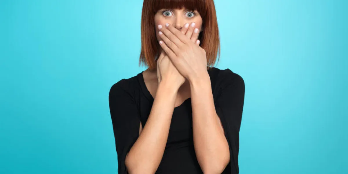 belle, jeune femme, avec une expression de visage surpris, couvrant sa bouche, sur fond bleu belle, jeune femme, avec une expression de visage surpris, couvrant sa bouche, sur fond bleu