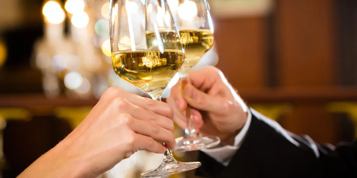 couple heureux ont un rendez-vous romantique dans un restaurant gastronomique, ils boivent du vin et des verres tintant, acclamations - un grand lustre est en arrière-plan couple heureux ont un rendez-vous romantique dans un restaurant gastronomique, ils boivent du vin et des verres tintant, acclamations - un grand lustre est en arrière-plan
