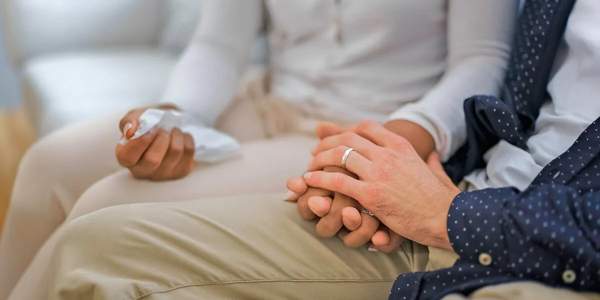 a hand holding tissu of a couple sit on sofa a hand holding tissu of a couple sit on sofa