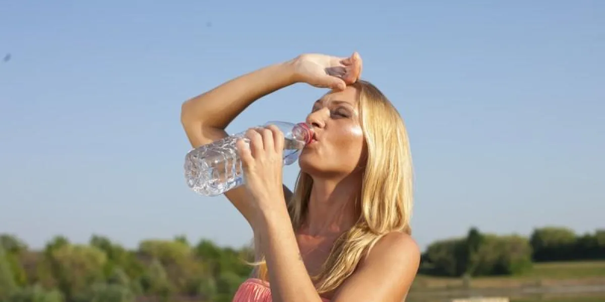 junge frau trinkt in der hitze mineralwasser junge frau trinkt in der hitze mineralwasser