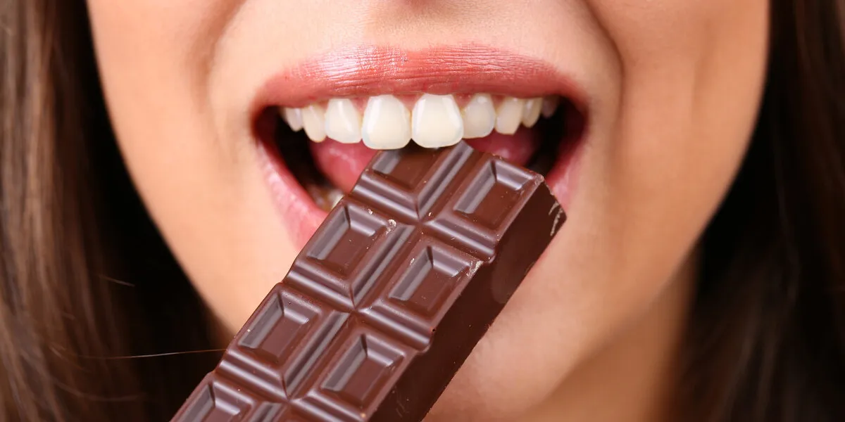 closeup of woman eating chocolate closeup of woman eating chocolate