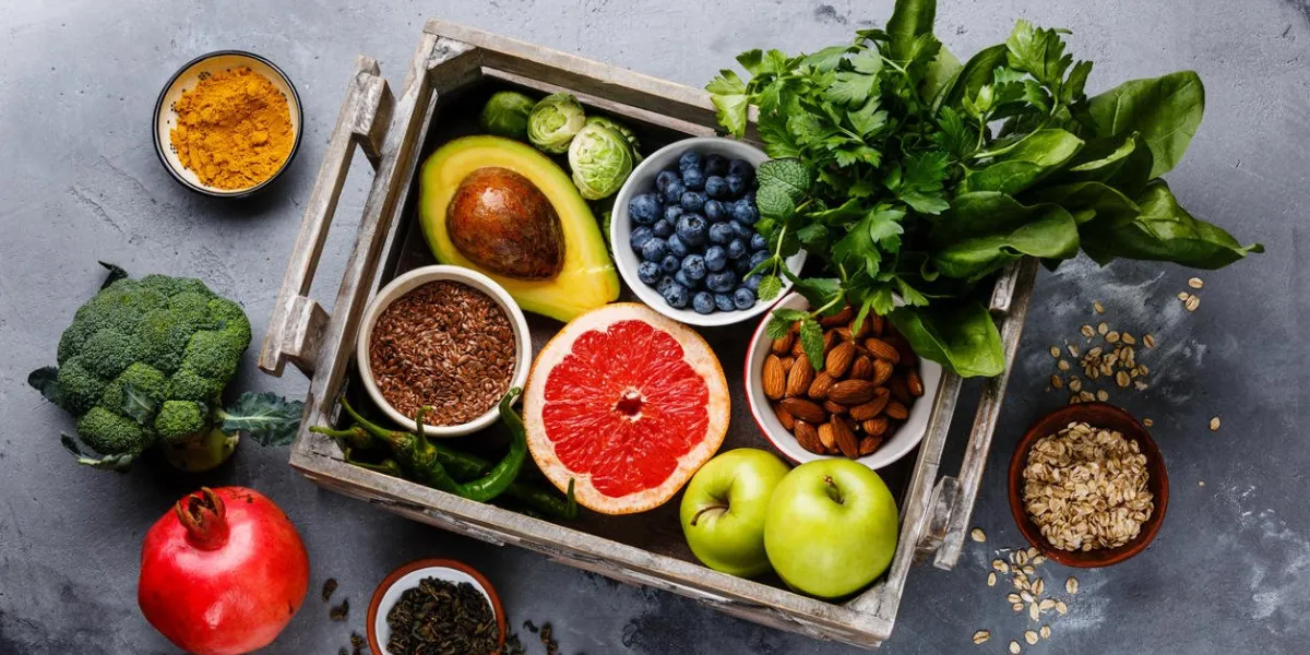 healthy food clean eating selection in wooden box fruit, vegetable, seeds, superfood, cereals, leaf vegetable on gray concrete background healthy food clean eating selection in wooden box fruit, vegetable, seeds, superfood, cereals, leaf vegetable on gray concrete background