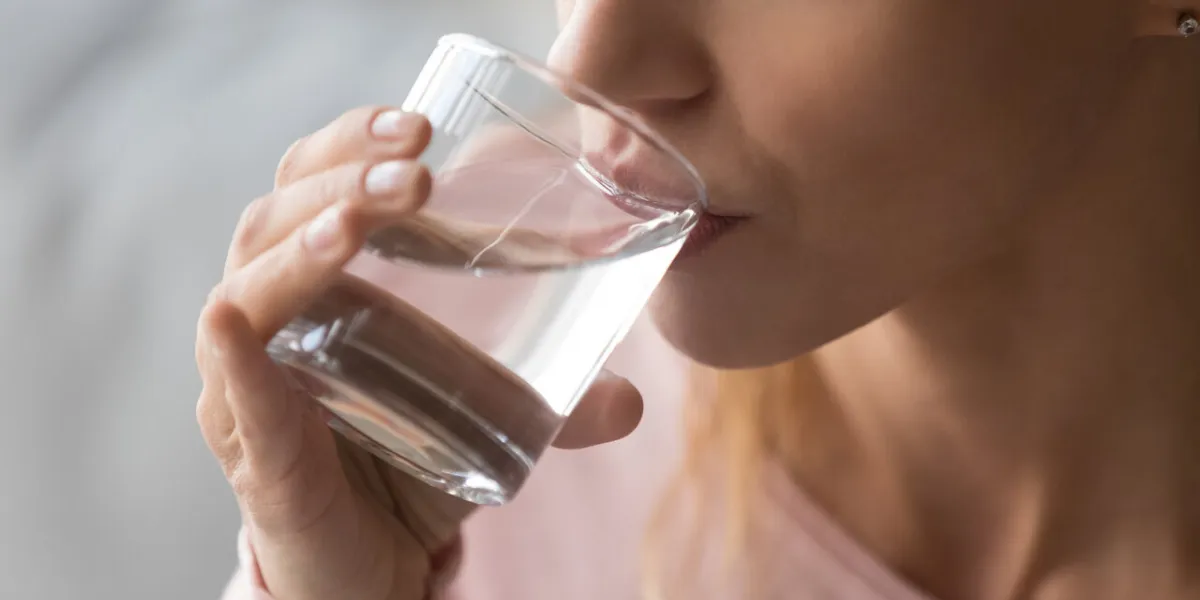 close up cropped image thirsty woman holding glass drinks still water preventing dehydration, helps maintain normal bowel function and balance of body, skin and health care, healthy lifestyle concept close up cropped image thirsty woman holding glass drinks still water preventing dehydration, helps maintain normal bowel function and balance of body, skin and health care, healthy lifestyle concept